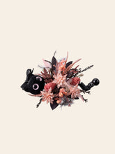 The CAMELLIA Cat Flower Ring is a handcrafted decorative bouquet with pink and brown dried flowers, featuring a small black plush cat with large eyes and a black handle.
